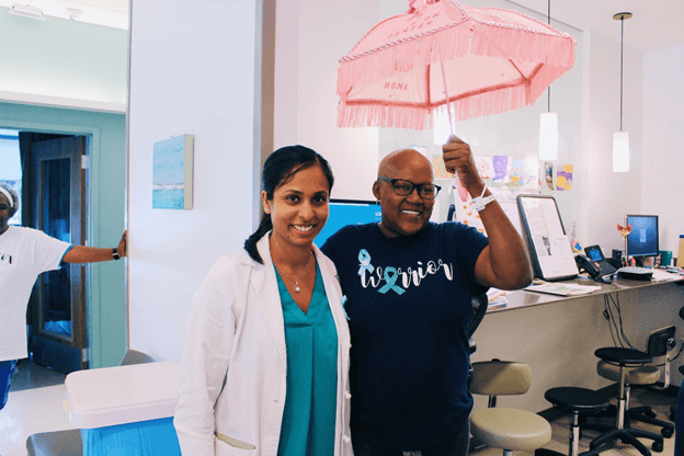 Jacqueline Holding pink umbrella beside a doctor